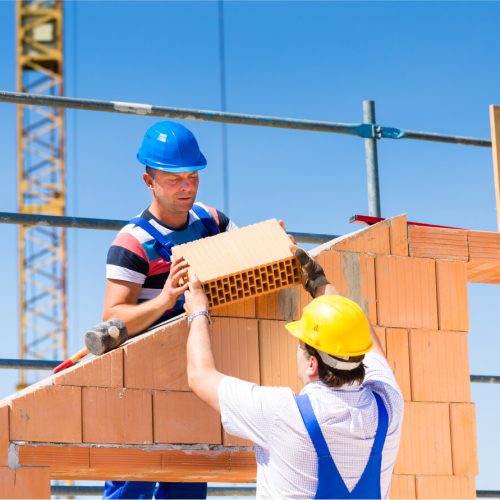 two men holding brick